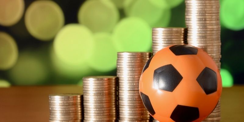 Một người chơi đang cẩn trọng phân tích các biểu đồ và số liệu thống kê trên thiết bị điện tử để đưa ra quyết định